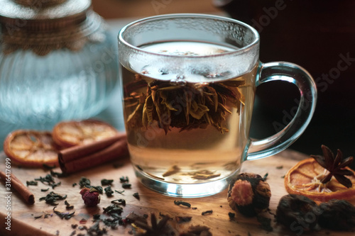 flower tea in a transparent mug with welding and spices/ vintage bottle and clay teapot