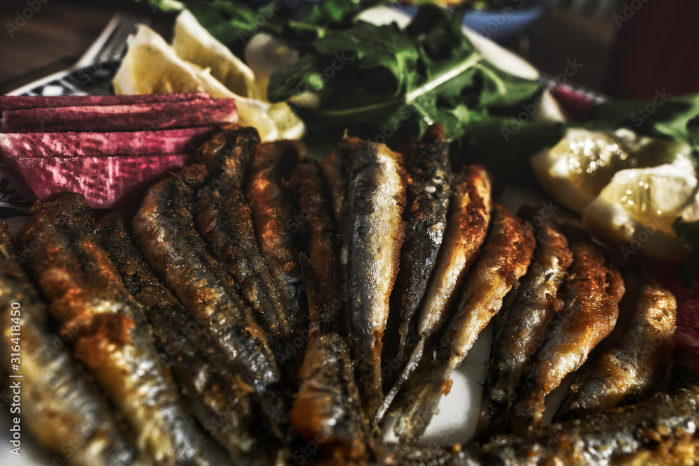 fresh fish and dinner roast anchovy platter, on wooden table. fresh fish and dinner roast anchovy platter, on wooden table.