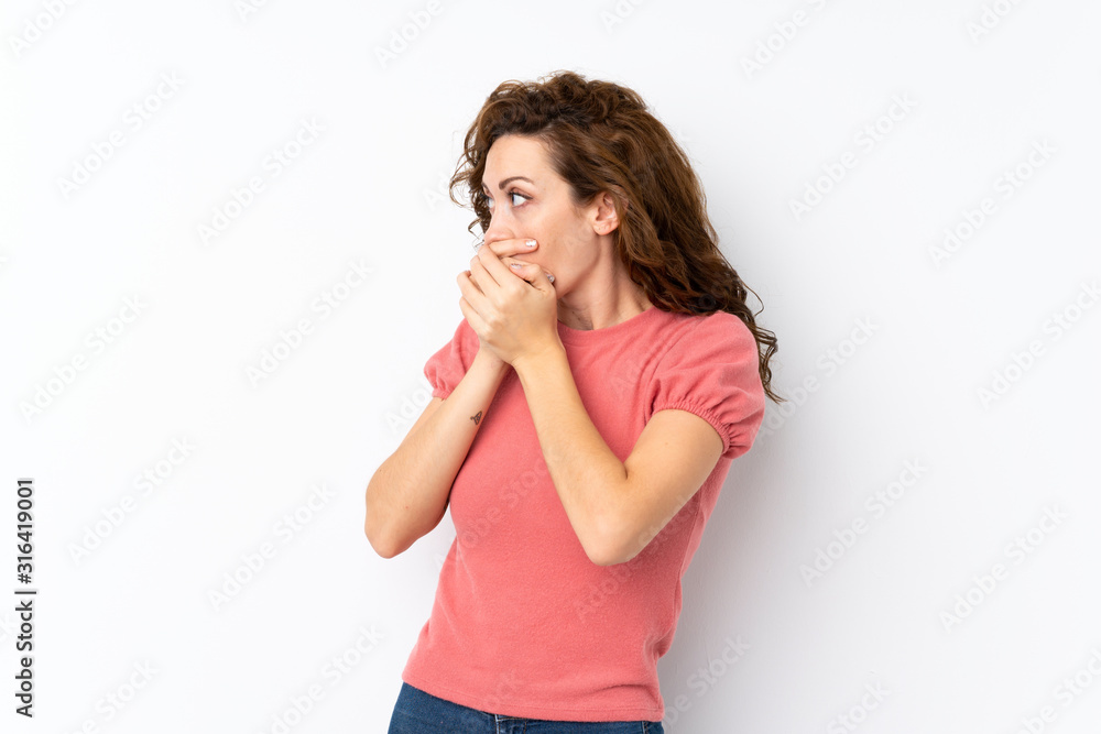 Young pretty woman over isolated background covering mouth and looking to the side Young pretty woman over isolated background covering mouth and looking to the side