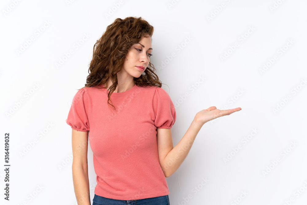 Young pretty woman over isolated background holding copyspace with doubts Young pretty woman over isolated background holding copyspace with doubts