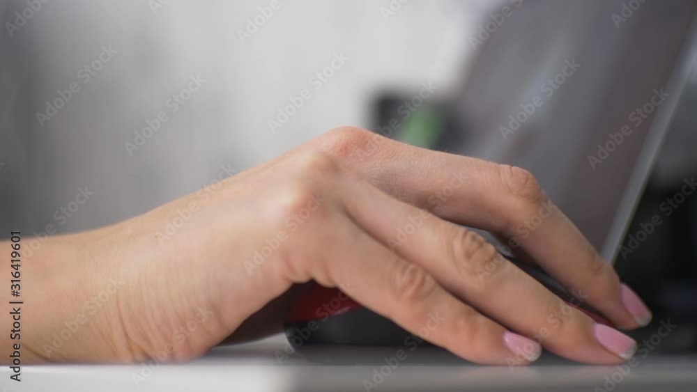 girl hand is on the mouse which is sitting at a laptop girl hand is on the mouse which is sitting at a laptop