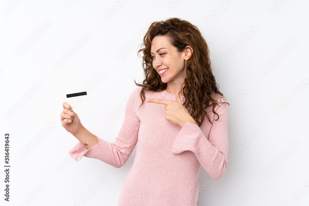 Young pretty woman over isolated background holding a credit card Young pretty woman over isolated background holding a credit card