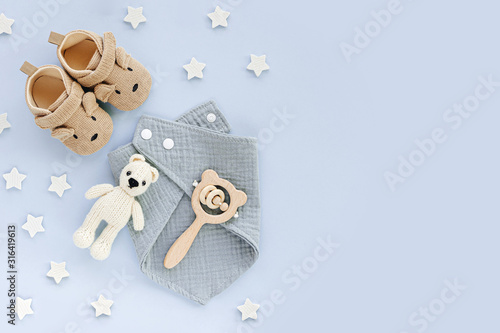 Set of baby shoes, toys and accessories on blue background. Fashion newborn stuff. Flat lay, top view