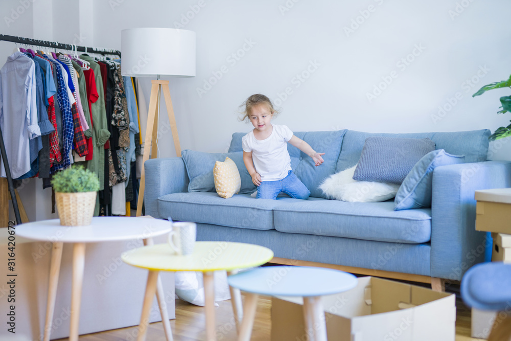 Beautiful toddler child girl jumping on the sofa Beautiful toddler child girl jumping on the sofa