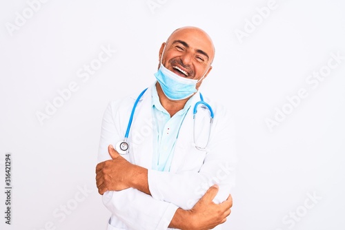 Middle age doctor man wearing stethoscope and mask over isolated white background happy face smiling with crossed arms looking at the camera. Positive person.