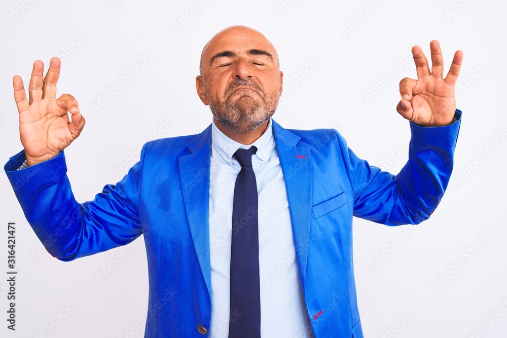 Middle age businessman wearing suit standing over isolated white background relaxed and smiling with eyes closed doing meditation gesture with fingers. Yoga concept. Middle age businessman wearing suit standing over isolated white background relaxed and smiling with eyes closed doing meditation gesture with fingers. Yoga concept.
