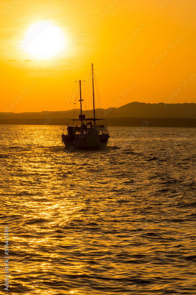 Sunset at sea. toned. Yacht in the sunset. copy space. vertical pgoto