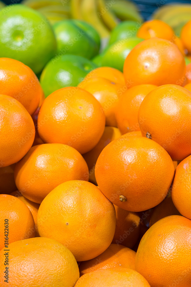 Fresh oranges in the store. Close up view of madarines orange on the sheft in the supermarket. Healty and fresh fruits background in a supermarket super store. vertical photo Fresh oranges in the store. Close up view of madarines orange on the sheft in the supermarket. Healty and fresh fruits background in a supermarket super store. vertical photo