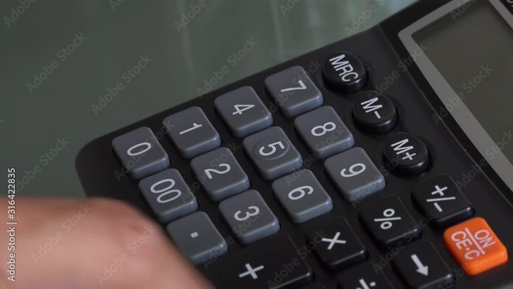 4K close up video of accountant hand using a classic financial calculator and pressing keys to compute numbers. Classic calculator with grey keys and black colour. Investment or investing concept 4K close up video of accountant hand using a classic financial calculator and pressing keys to compute numbers. Classic calculator with grey keys and black colour. Investment or investing concept