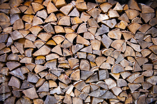 Pile of wood logs ready for winter - landscape exterior. tree stumps texture. Wooden background - natural brown texture