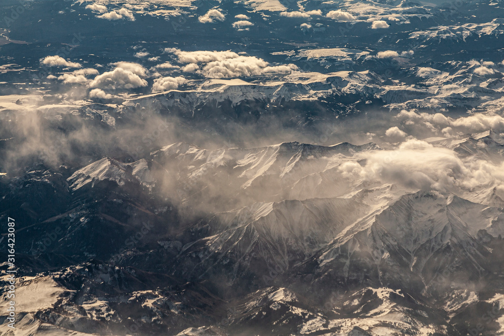 Flying over snowy mountains in the central United States.  