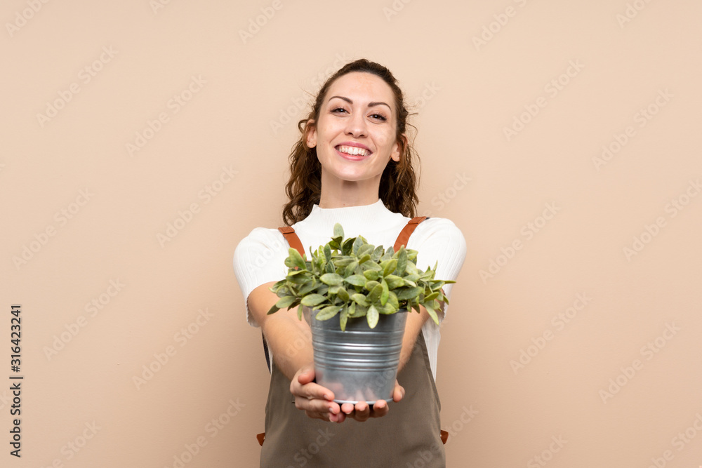Gardener woman holding a plant Gardener woman holding a plant