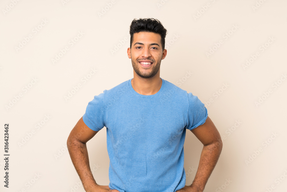 Young handsome man over isolated background posing with arms at hip and smiling Young handsome man over isolated background posing with arms at hip and smiling