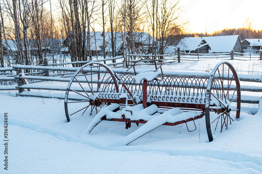 Rake for horses. An ancient device designed to collect hay and driven by horses. Snow covered rake