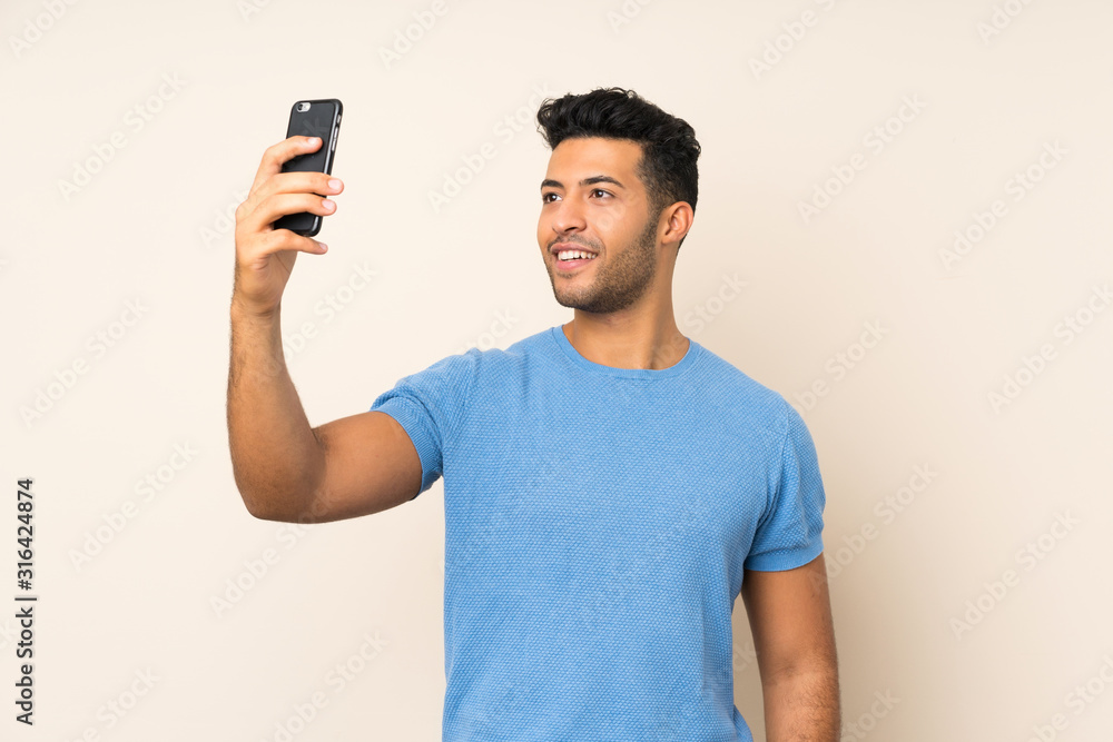 Young handsome man over isolated background making a selfie Young handsome man over isolated background making a selfie