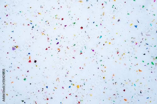 confetti scattered in the snow. Festive background. Abstract composition