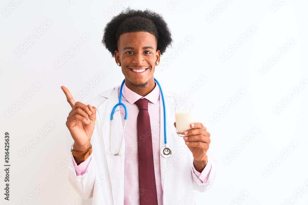 Young african american doctor man drinking glass of milk over isolated white background very happy pointing with hand and finger to the side Young african american doctor man drinking glass of milk over isolated white background very happy pointing with hand and finger to the side