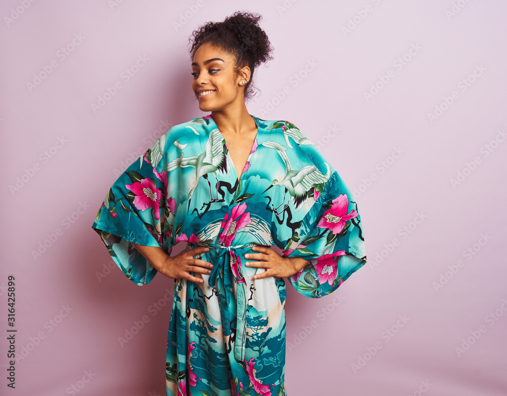 Young beautiful african american woman standing wearing elegant colorful caftan Young beautiful african american woman standing wearing elegant colorful caftan