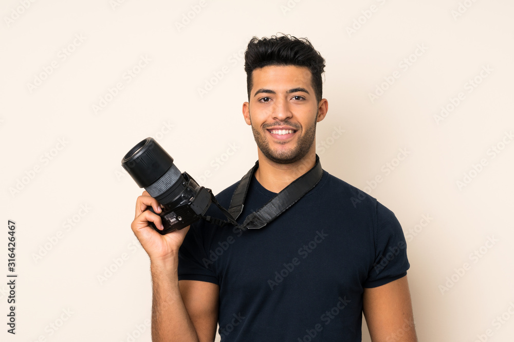 Young handsome man over isolated background with a professional camera Young handsome man over isolated background with a professional camera