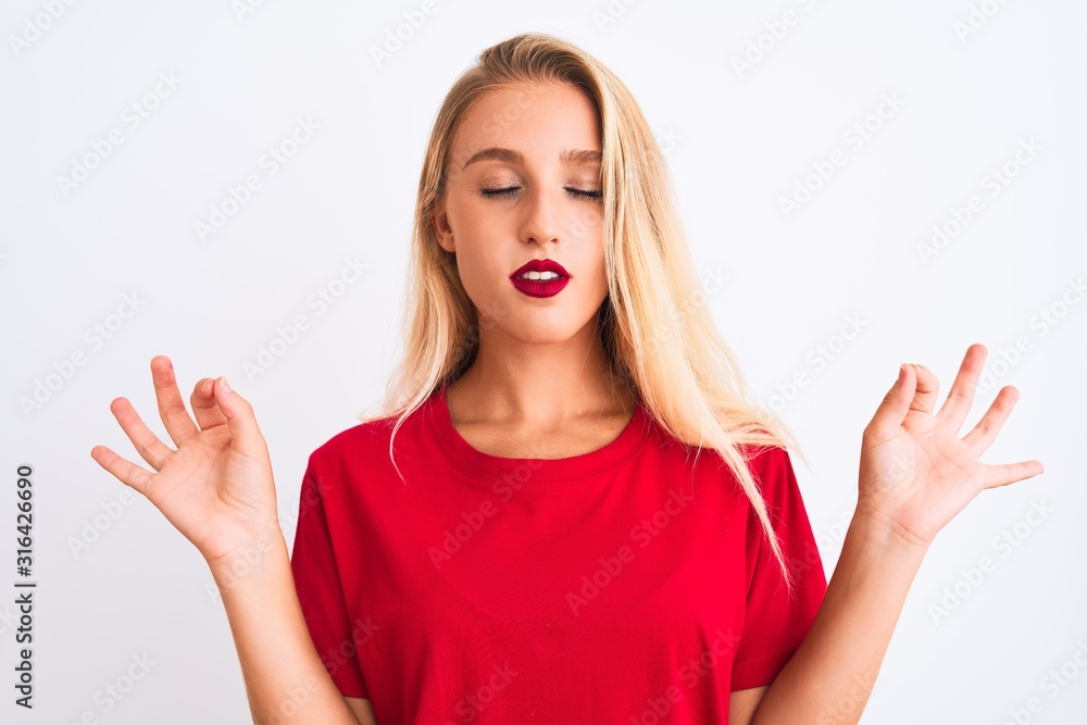 Young beautiful woman wearing red casual t-shirt standing over isolated white background relax and smiling with eyes closed doing meditation gesture with fingers. Yoga concept. Young beautiful woman wearing red casual t-shirt standing over isolated white background relax and smiling with eyes closed doing meditation gesture with fingers. Yoga concept.