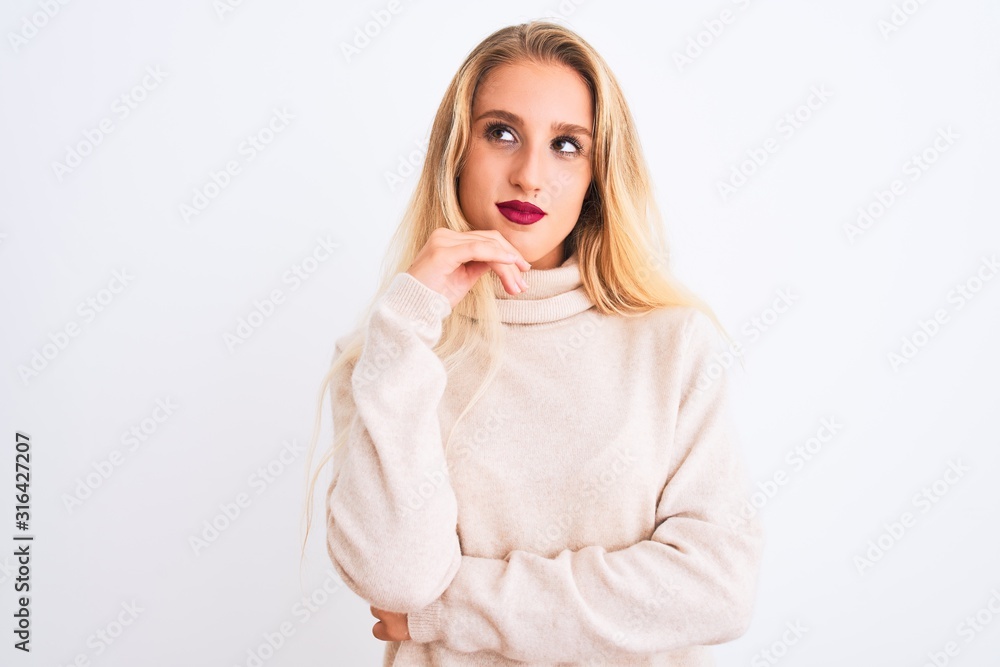 Young beautiful woman wearing turtleneck sweater standing over isolated white background with hand on chin thinking about question, pensive expression. Smiling with thoughtful face. Doubt concept. Young beautiful woman wearing turtleneck sweater standing over isolated white background with hand on chin thinking about question, pensive expression. Smiling with thoughtful face. Doubt concept.