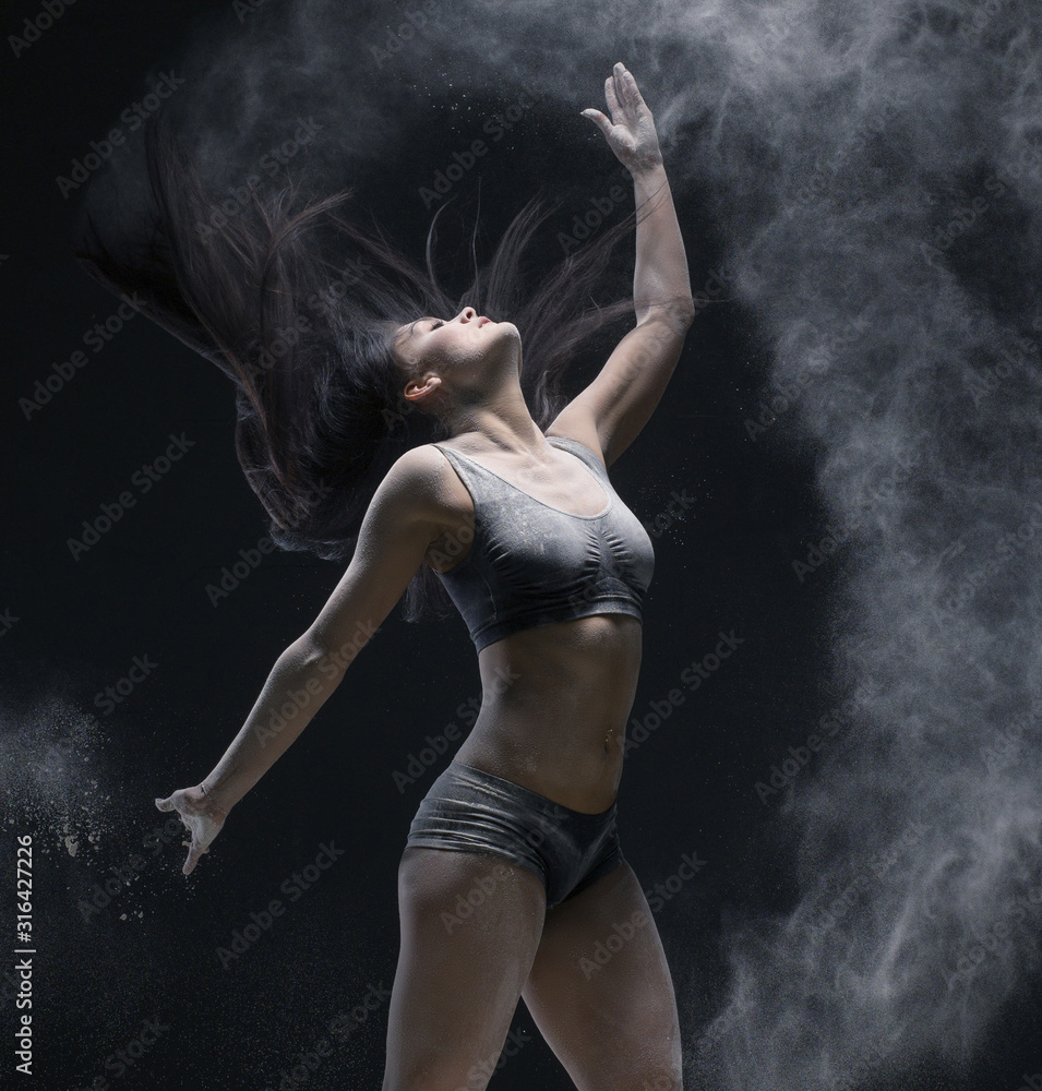 Woman jumping gracefully in dust cloud view