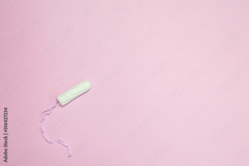 The uncompressed tampons white on a pink background, the concept of women's intimate hygiene and health. The uncompressed tampons white on a pink background, the concept of women's intimate hygiene and health.