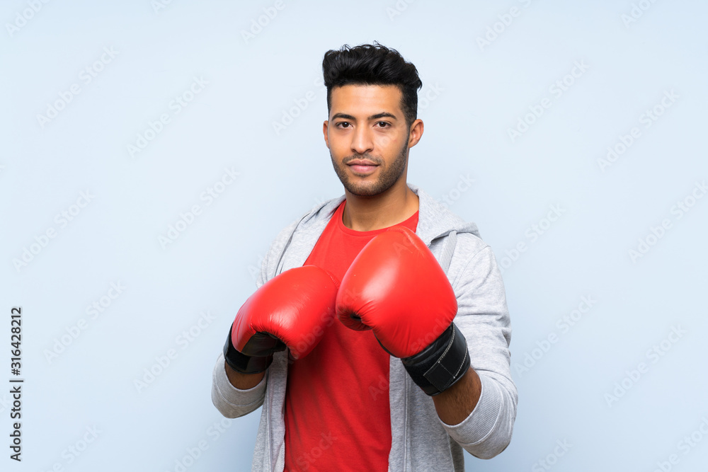 Sport man with boxing gloves over isolated blue wall