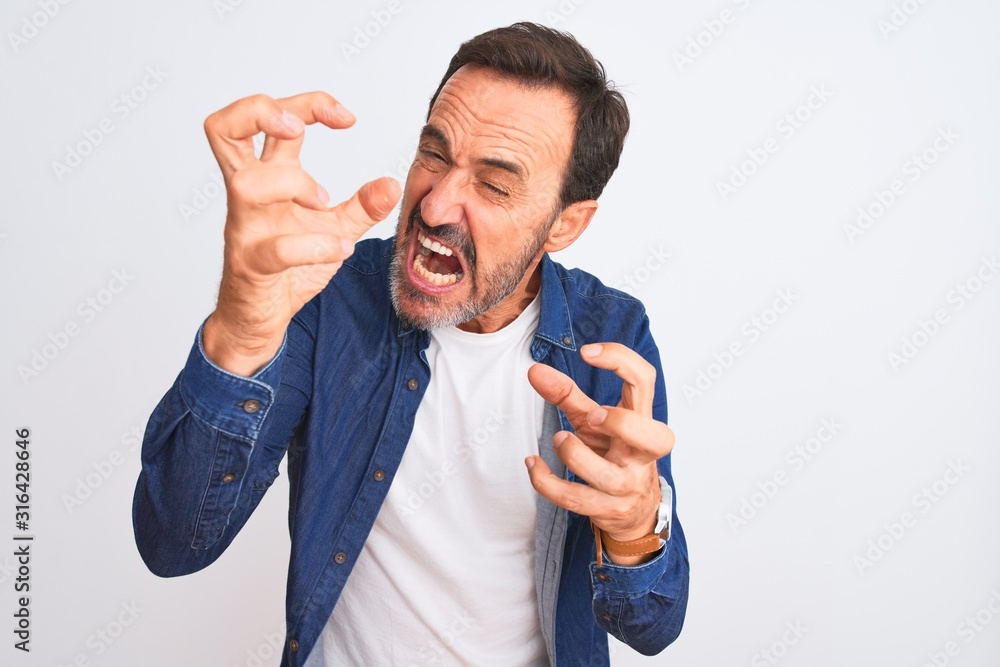 Middle age handsome man wearing blue denim shirt standing over isolated white background Shouting frustrated with rage, hands trying to strangle, yelling mad Middle age handsome man wearing blue denim shirt standing over isolated white background Shouting frustrated with rage, hands trying to strangle, yelling mad