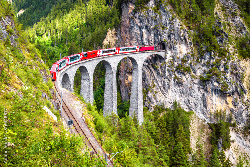 Red train of Bernina Express on Landwasser Viaduct in summer, Switzerland.  It is landmark of Swiss Alps. Stock Photo | Adobe Stock