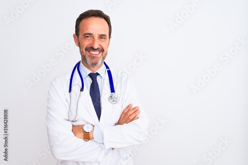 Middle age doctor man wearing coat and stethoscope standing over isolated white background happy face smiling with crossed arms looking at the camera. Positive person. photo