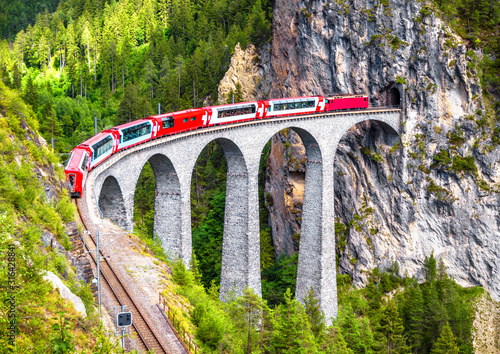 Bernina Express train on Landwasser Viaduct, Switzerland. Aerial scenic view of famous railway in Swiss Alps. photo