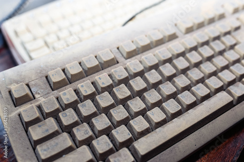 Dusty retro computer keyboard. obsolete technology concept.