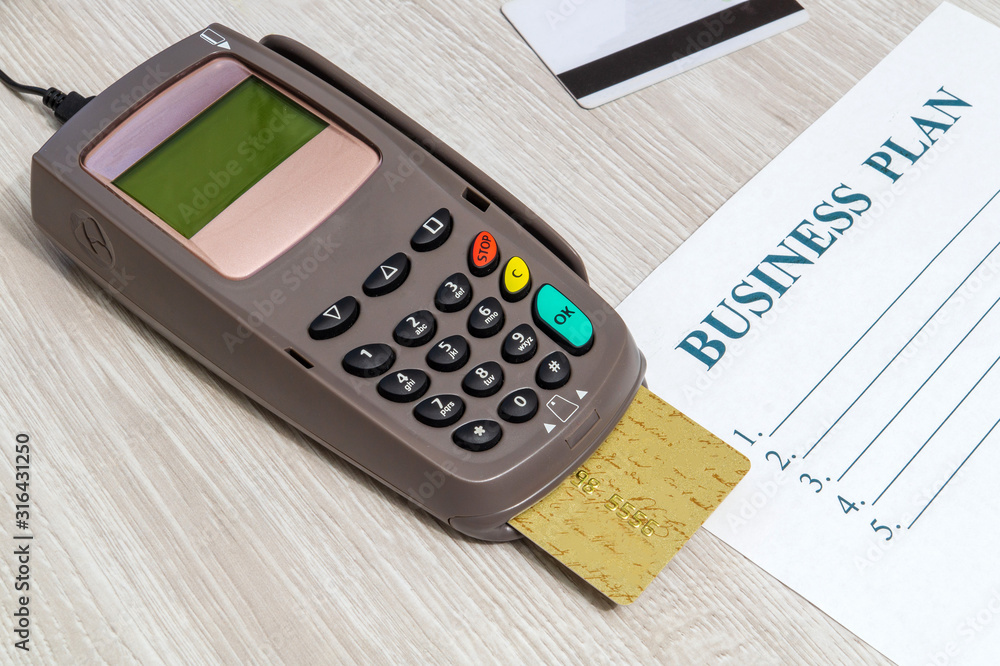 Payment terminal with card for receiving money on office desk Payment terminal with card for receiving money on office desk