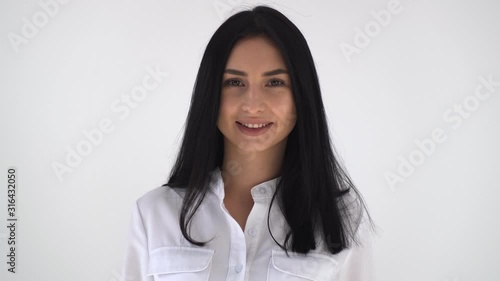 The brunette nods approvingly at the camera. A young girl in a white blouse nods approvingly at the camera smiling broadly