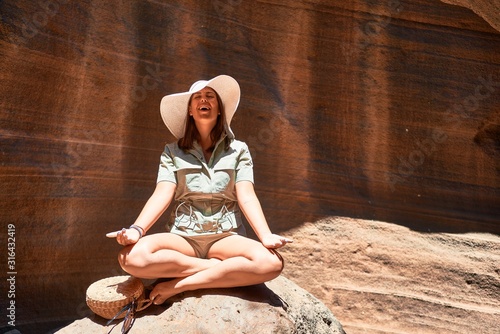 Young beauitufl hiker woman trekking natural orange mountain doing yoga pose on summer holidays photo