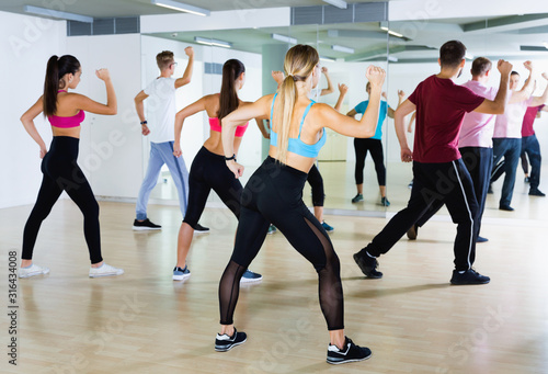 Fototapeta Naklejka Na Ścianę i Meble -  Men women performing modern dance in fitness studio