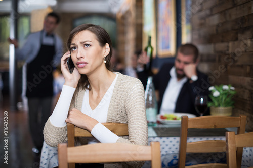  upset woman holding phone in the restaurant