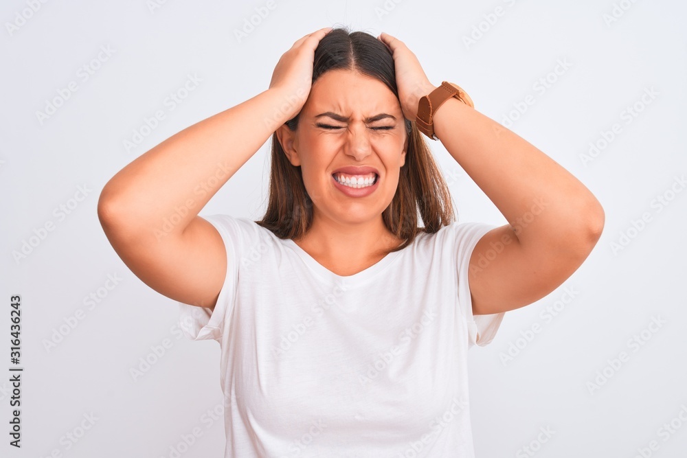 Portrait of beautiful and young brunette woman standing over isolated white background suffering from headache desperate and stressed because pain and migraine. Hands on head. Portrait of beautiful and young brunette woman standing over isolated white background suffering from headache desperate and stressed because pain and migraine. Hands on head.