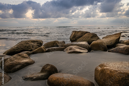 Rocks on the beach at the pacific sunset © Gabriel O.