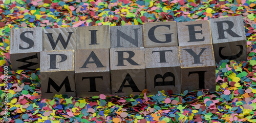 Swinger Party geschrieben auf Holzwürfel und isoliert auf Konfetti Hintergrund photo