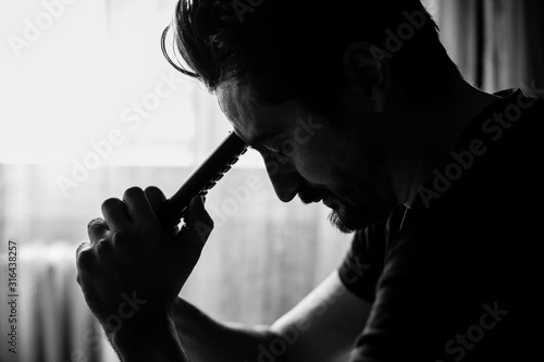 Man holding a TV remote and leaning his head