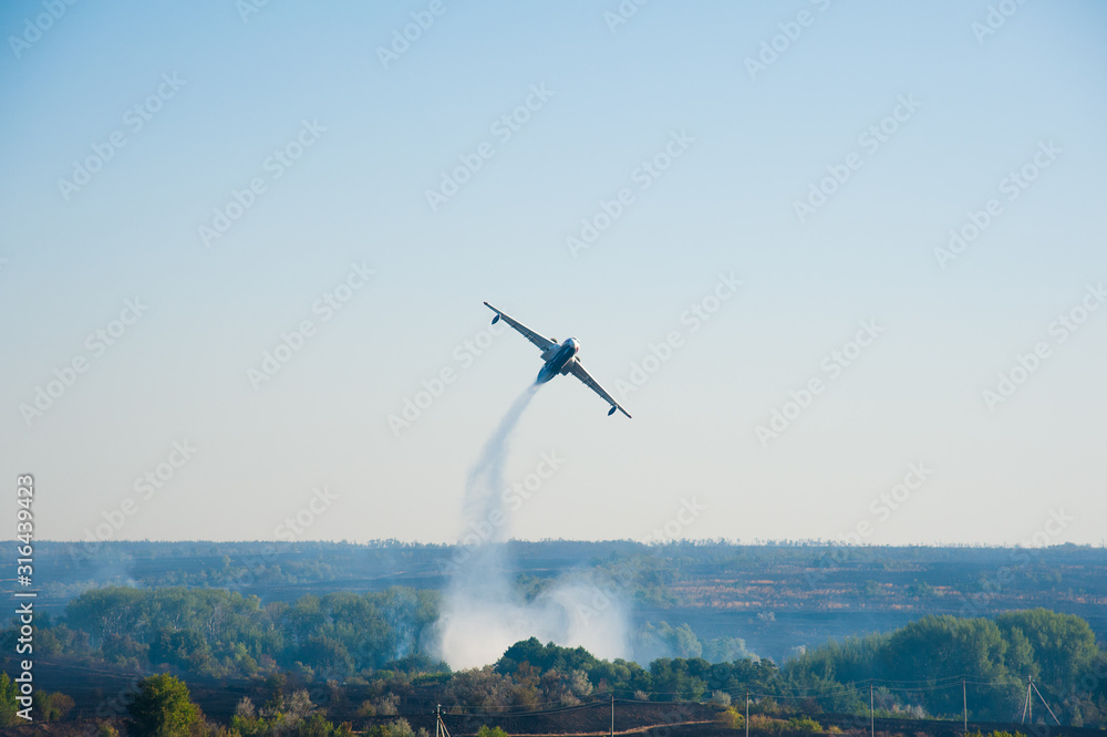 Obraz premium Firefighter airplane extinguishes a forest fire