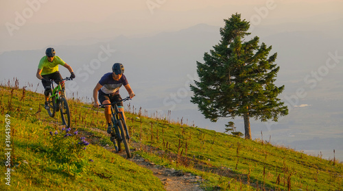 Young friends race on their electric bikes in the mountains on a sunny morning © helivideo