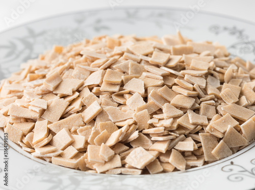 Turkish pasta (eriste) in a bowl isolated on white. Cut dough ready to bake. photo