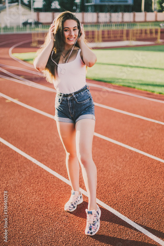 Stylish woman posing for the camera on running track.