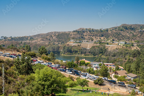 Wallpaper Mural parked cars opposite a hill with the words hollywood, people are taking pictures at the famous symbol of america Torontodigital.ca