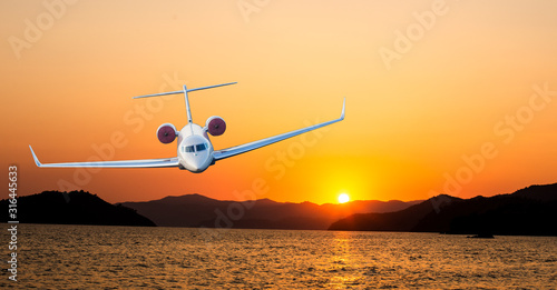 Airplane flying above dramatic clouds during sunset