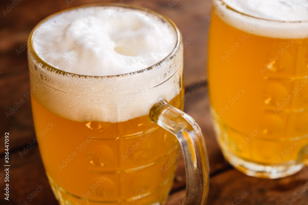 Close-up two cold beers with foam and drops. Close-up two cold beers with foam and drops.