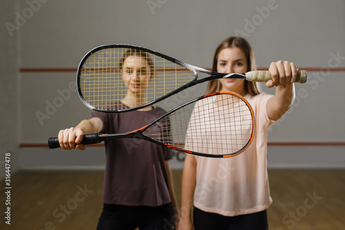 Two female players shows squash rackets © Nomad_Soul